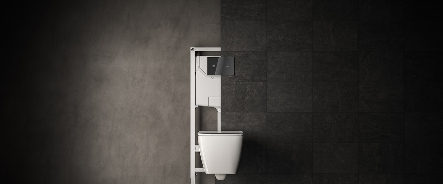 Photo de la collection ProSys mise en ambiance représentant un bâti-support WC à la fois devant et derrière un mur carrelé gris foncé avec une cuvette suspendue blanche et une plaque de commande noire